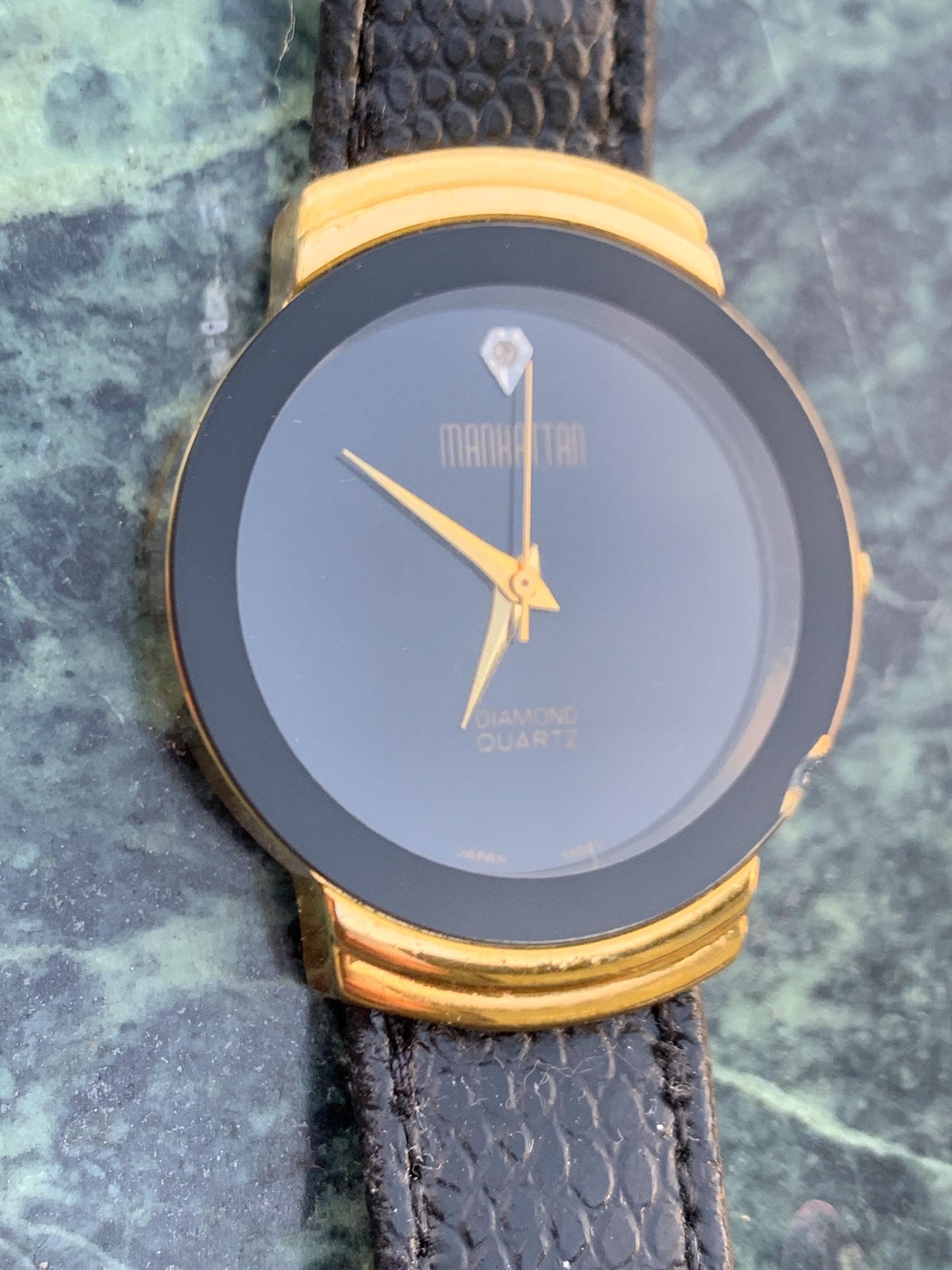Manhattan 'Diamond' Quartz Museum watch. Fancy lugs, great gold tone. Black dial without indices. Keeps time well. 1990s. Small chip crystal
