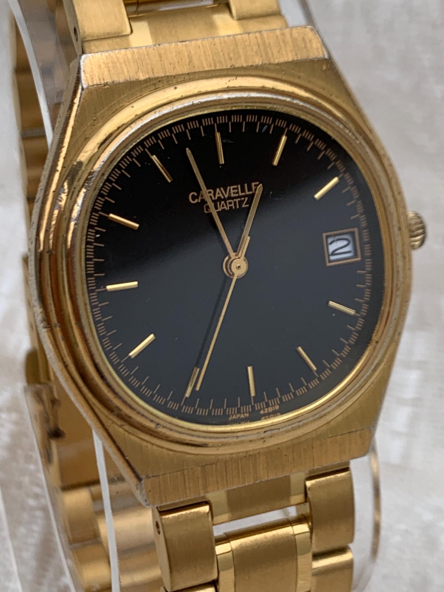 Worn 1992 Caravelle Cushion Quartz Watch by Bolova Gold Tone Finish, Black Dial with Date, New battery. New Bracelet. Presentable.
