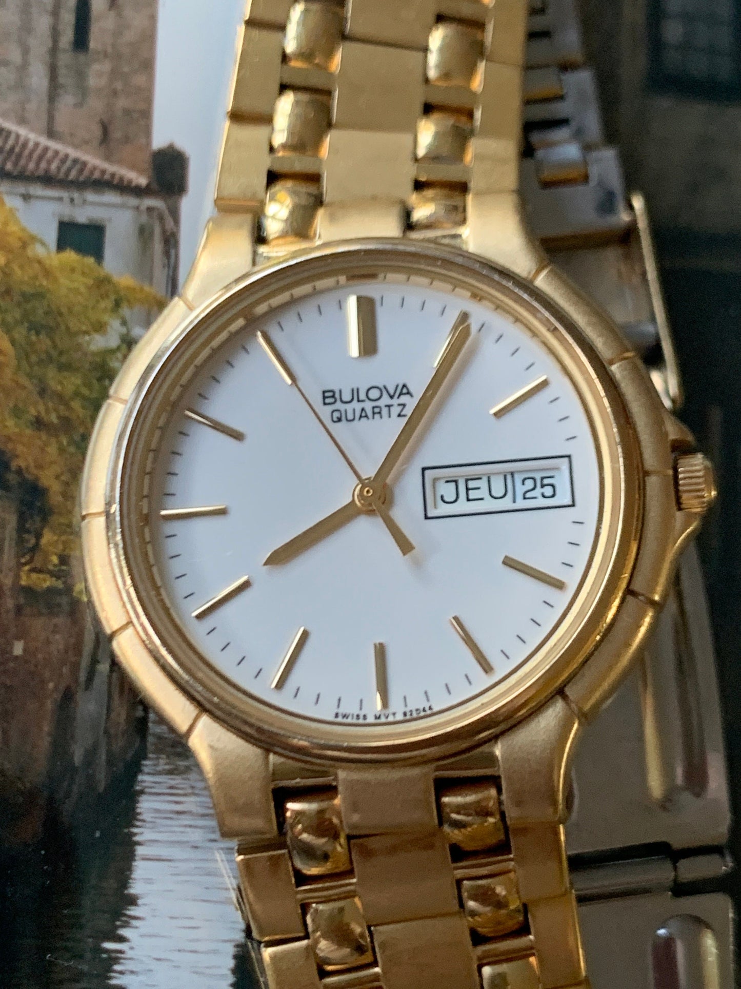 1988 Bulova Quartz Watch Gold Tone Finish, White Dial with Day/Date New battery. Original, integral metal band. Neo Vintage Quartz. Great.