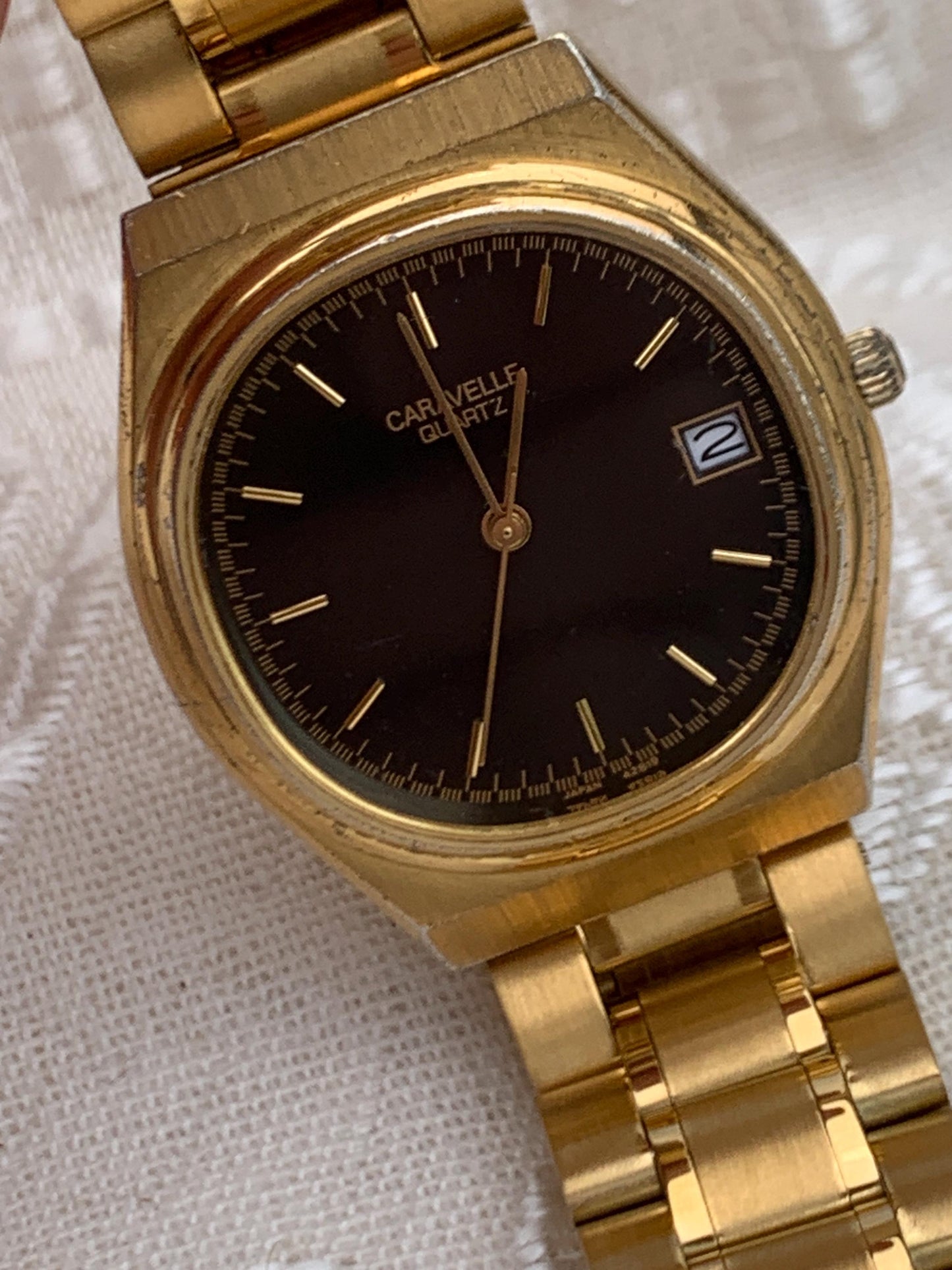 Worn 1992 Caravelle Cushion Quartz Watch by Bolova Gold Tone Finish, Black Dial with Date, New battery. New Bracelet. Presentable.