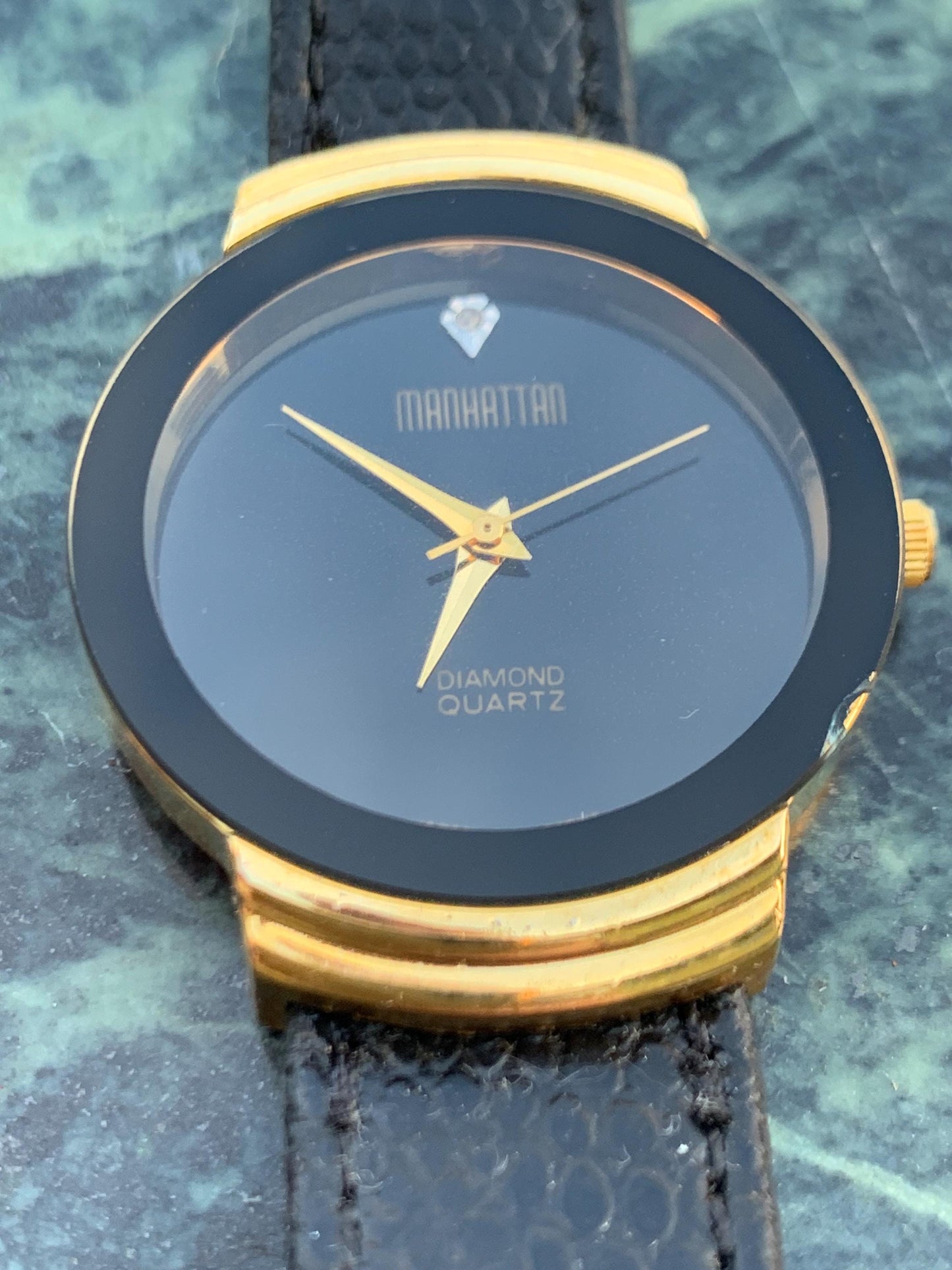 Manhattan 'Diamond' Quartz Museum watch. Fancy lugs, great gold tone. Black dial without indices. Keeps time well. 1990s. Small chip crystal
