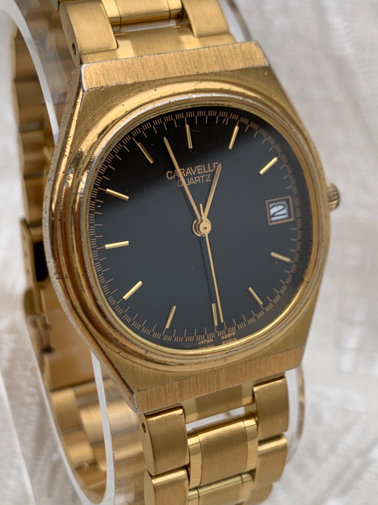 Worn 1992 Caravelle Cushion Quartz Watch by Bolova Gold Tone Finish, Black Dial with Date, New battery. New Bracelet. Presentable.