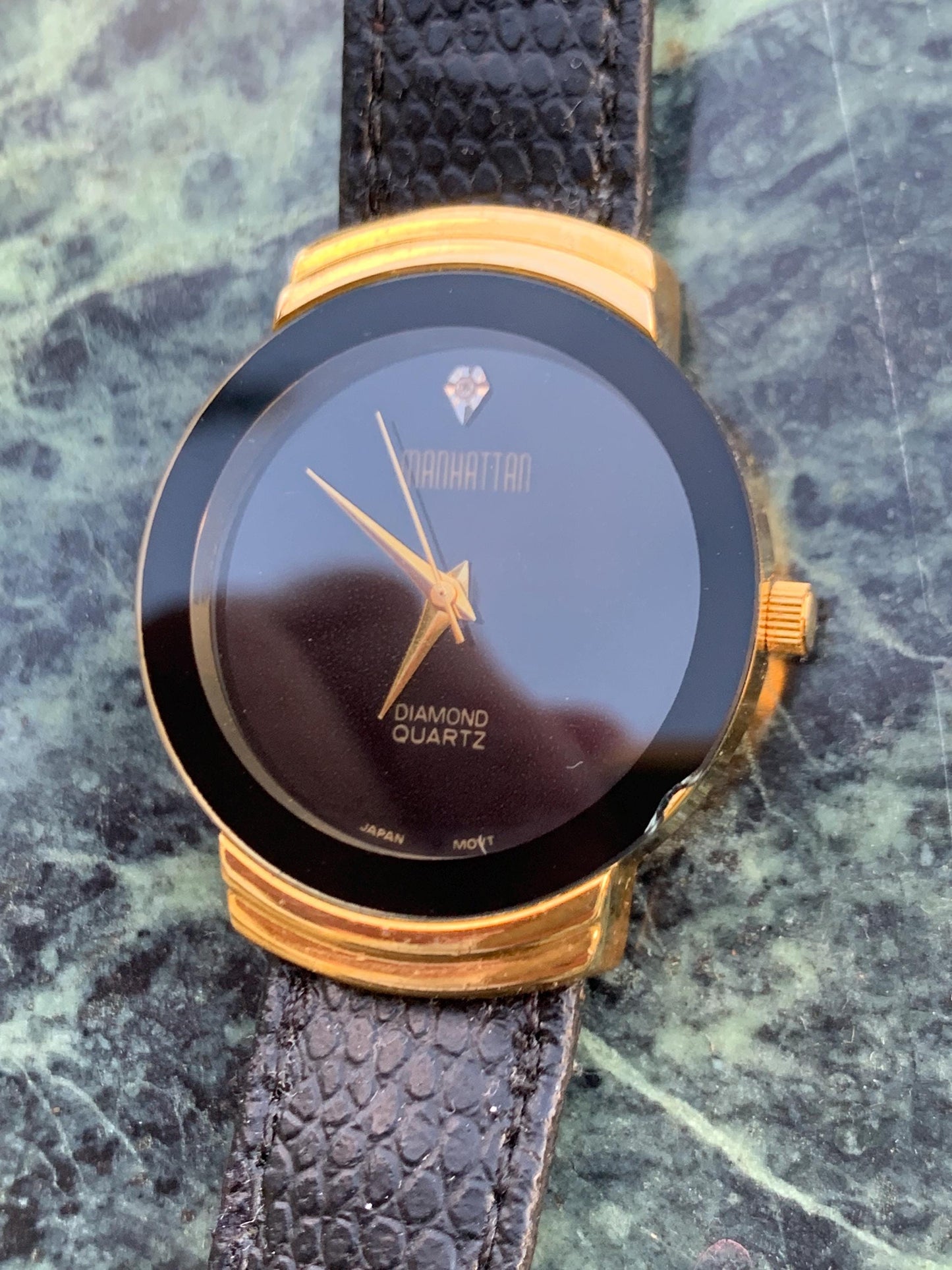 Manhattan 'Diamond' Quartz Museum watch. Fancy lugs, great gold tone. Black dial without indices. Keeps time well. 1990s. Small chip crystal