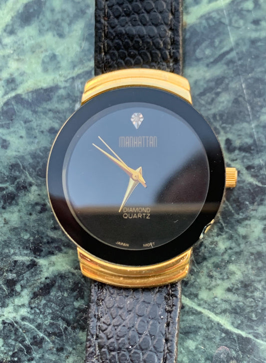 Manhattan 'Diamond' Quartz Museum watch. Fancy lugs, great gold tone. Black dial without indices. Keeps time well. 1990s. Small chip crystal